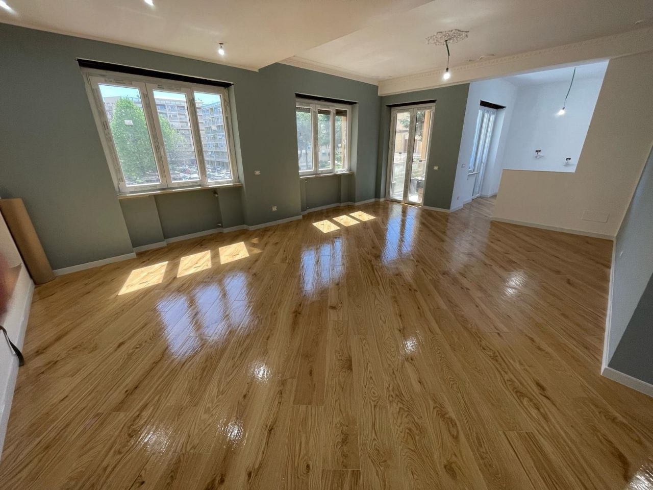 Sala ampia ristrutturata con pavimento effetto legno lucido